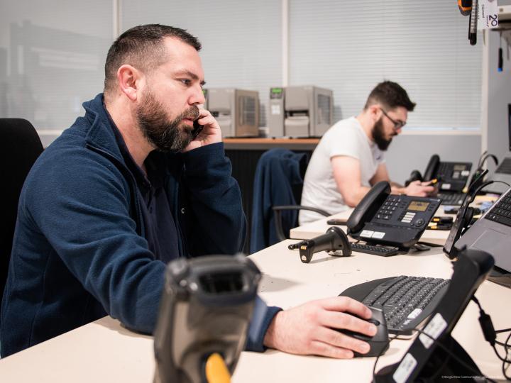 Photo de deux collaborateurs TIMCOD qui portent assistance au téléphone 