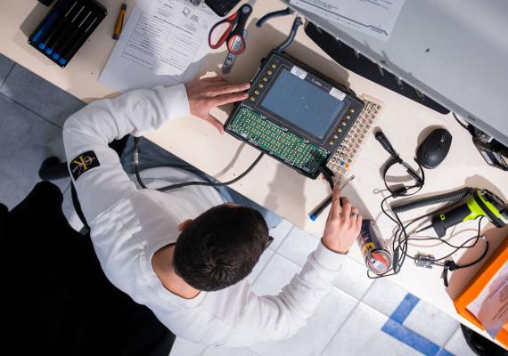 photo en vue du dessus avec un technicien TIMCOD qui répare un terminal embarqué 