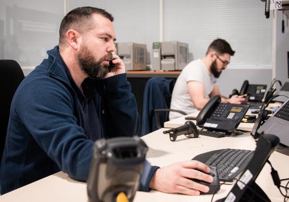 Photo de deux collaborateurs TIMCOD qui portent assistance au téléphone 